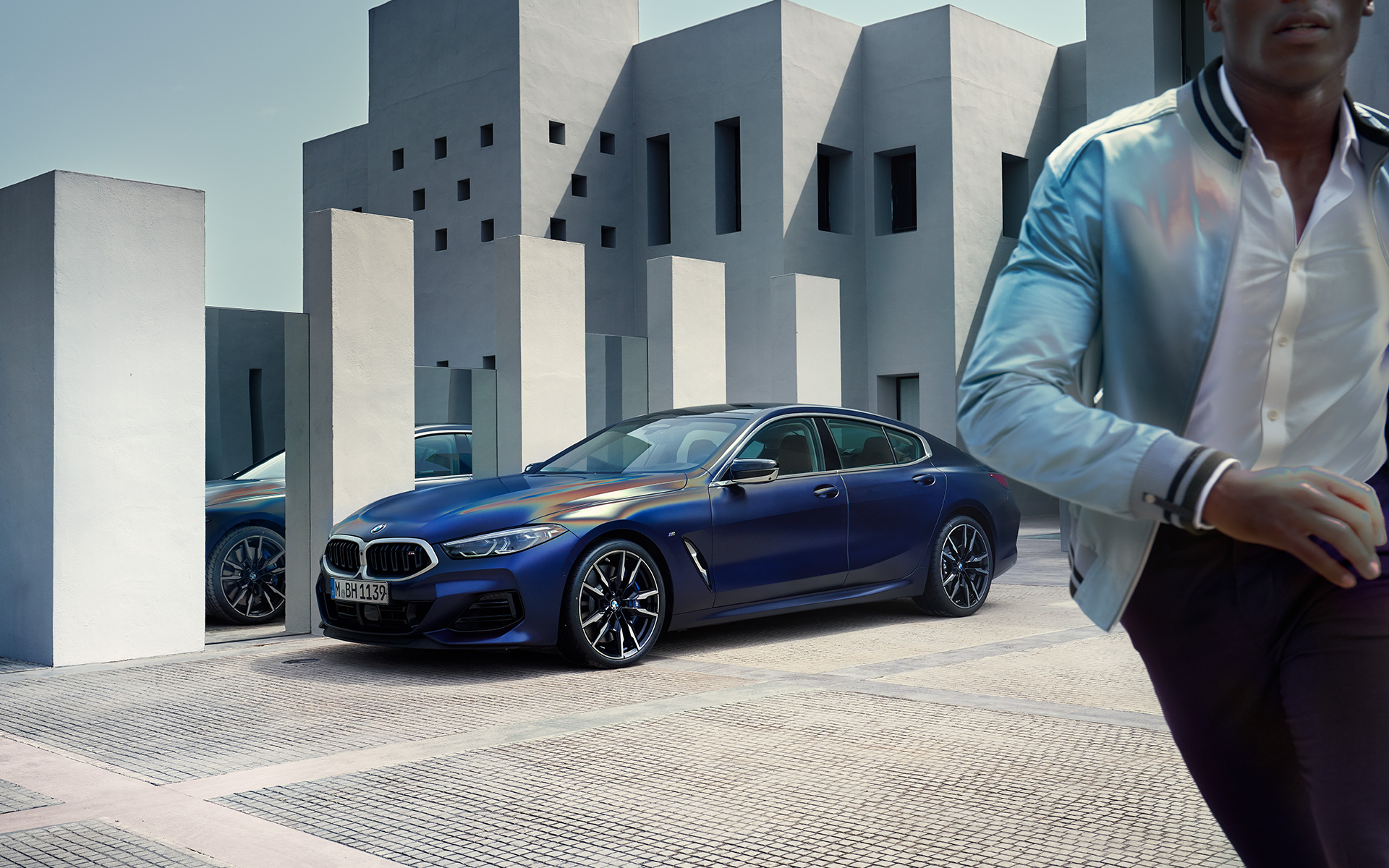 BMW M850i xDrive Gran Coupé G16 LCI restylage 2022 BMW Individual Frozen Tansanitblau metallic vue de trois quarts avant à l’arrêt avec modèle masculin au premier plan